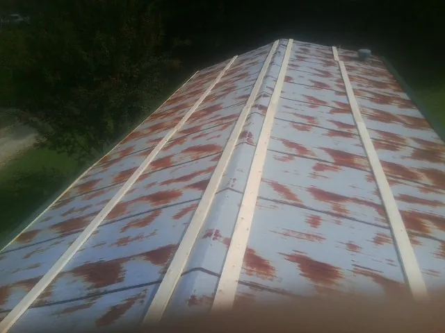 Rusted metal roof panels with new wood purlins before replacement — Storm Damage Roof Repair in Fairland by Roofing Brothers
